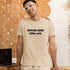 Working More Living Less relatable work humor shirt in soft cream — lightweight unisex tee perfect for casual wear