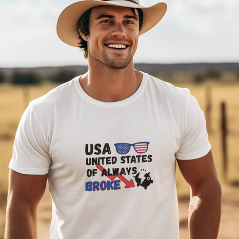 USA United States Of Always Broke graphic t-shirt with distressed black and blue text, red arrow, patriotic sunglasses, and broken piggy bank icon. Funny design for white, navy, or black shirts